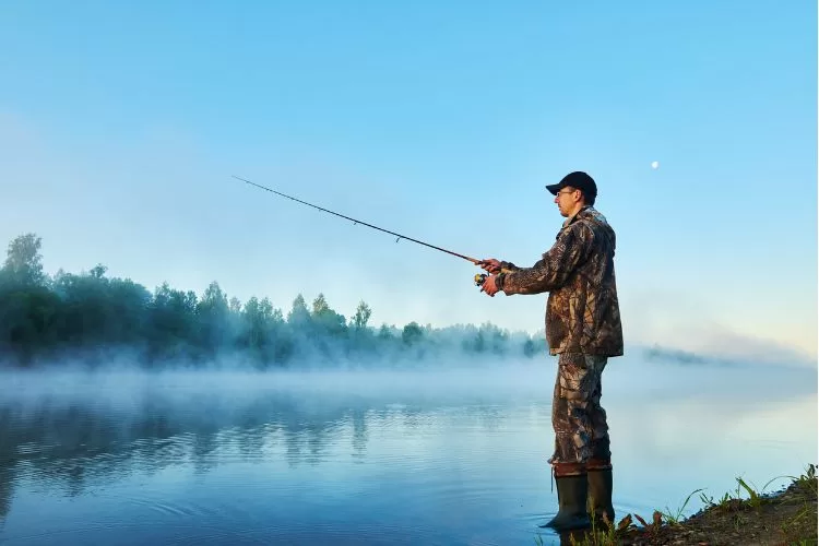 Fisherman fishing on foggy sunrise